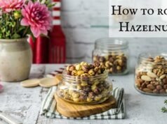 How to Roast Hazelnuts? In Easy Way Roasted hazelnuts on a baking sheet, with skins loosening after oven roasting for easy peeling.