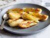 Make Caramelized Fennel in an Easy Way Golden caramelized fennel wedges arranged on a gray plate beside a spoon.